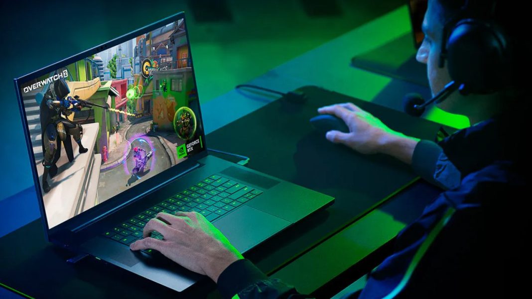 Um homem está jogando videogame em um laptop Razer na CES 2024 enquanto experimenta as mais recentes inovações em monitores.