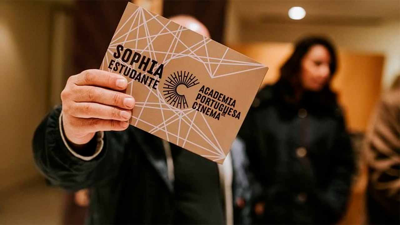 Pessoa exibindo com orgulho um papel com a palavra Sophia Estudante, após vencer os Prémios.