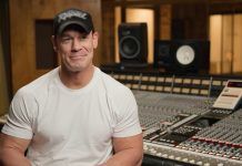 Mortal Kombat 1 | John Cena fala sobre Peacemaker da DC em MK1 Um homem sentado em um estúdio de gravação trabalhando na trilha sonora de Mortal Kombat.