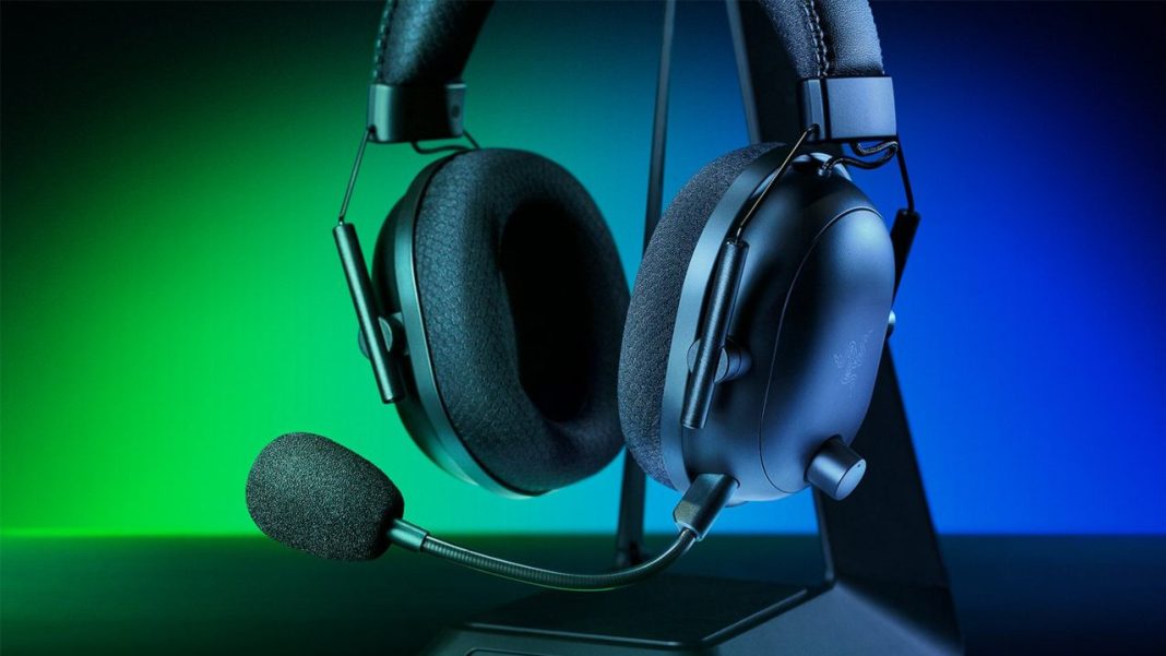 Fones de ouvido com microfone iluminado por luzes azuis e verdes em suporte, compatível com Xbox.